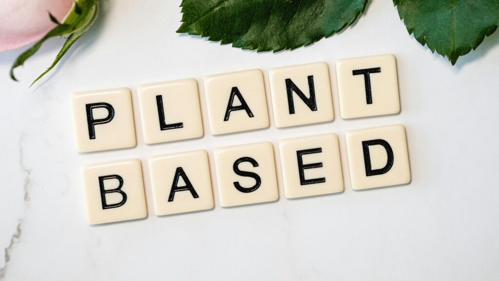 pexels-photo-3669638-3669638 Scrabble tiles spelling 'Plant Based' surrounded by green leaves, promoting a vegan lifestyle.