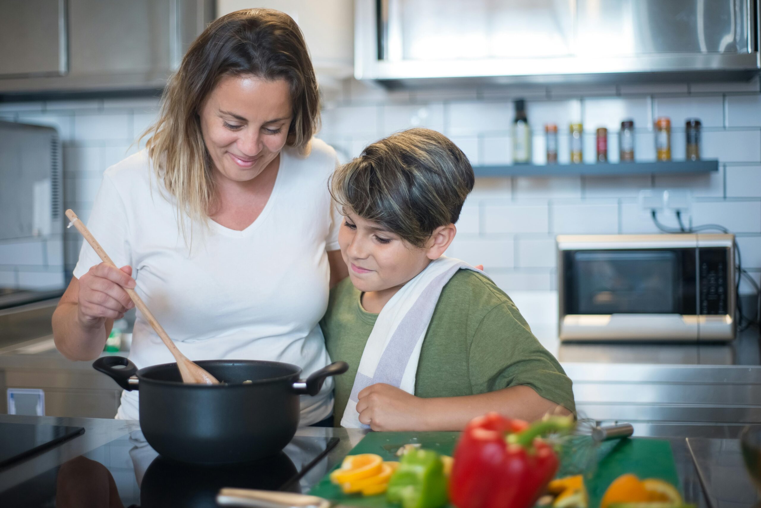 pexels-photo-8507648-8507648 A mother and son joyfully cooking together in a modern kitchen setting.